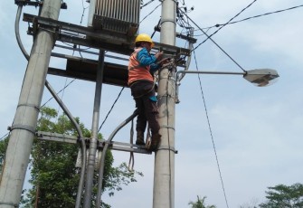 petugas saat memasang lampu penerangan jalan