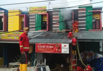 Petugas Damkar saat menjinakan api