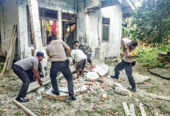 Personel Polres Simeulue saat membersihkan puing-puing bangunan yang roboh dan hancur