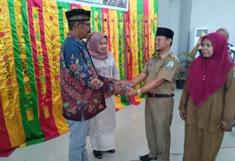 Kadisdikbud Aceh Singkil Khalilullah (kanan) saat menyerahkan cinderamata kepada Kadisdikbud lama H.Yusfit Helmi didampingi ibu.
