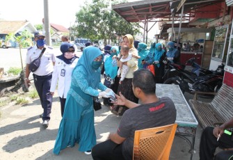 Ketua Tim penggerak PKK Kota Lhokseumawe Cut Ernita membagikan masker kepada warga masyarakat  di Terminal Bus Tipe A Kota Lhokseumawe Jumat (10/4)
