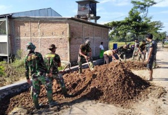 Anggota Satgas Rapikan Sisa Pekerjaan Talud