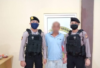 Tersangka (tengah) saat diamankan