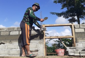 Sertu Jarno Susun Batako dalam Pembangunan Dinding Rumah Karyono