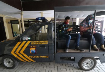 Dua siswa sedang belajar dengan wifi gratis di polsek puncu