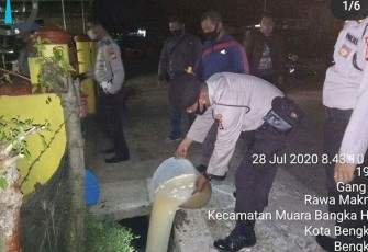 Petugas saat membuang tuak hasil sitaan dalam patroli