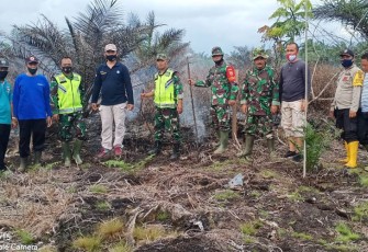 Polisi dan anggota TNI saat memeriksa titik api di lahan gambut Desa Rawa Bangun