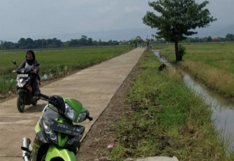 Rini warga Dukuh pening sedang melewati jalan betonisasi hasil TMMD Kodim0715/Kendal. Selasa 27/10/2020