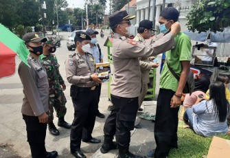 Kapolsek Pekalongan Utara Kompol Bakti Kautsar Ali,S.I.K,S.Sos memakaikan masker kepada masyarakat yang tidak taat prokes