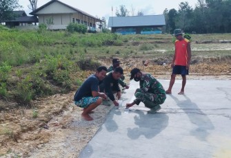 Prajurit TNI Satgas Pamtas RI-Malaysia Yonif 407/PK bersama masyarakat dengan gotong royong melaksanakan karya bhakti pengecatan lapangan voly di Desa Sungai Kelik, Kec. Ketungau Hulu, Kab. Sintang, Kalimantan Barat. Jum'at (26/03/21).