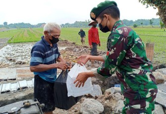 Personel Yonif Mekanis Raider 413/Bremoro membagikan nasi kotak kepada masyarakat dalam kegiatan bhakti sosial "Kostrad Peduli"