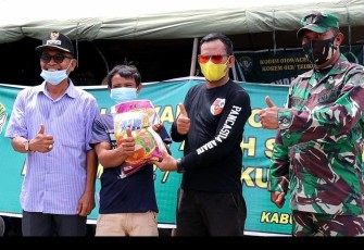 Pj Kades Rantau Gedang, Irwansyah Rizal (tengah) saat menyerahkan bantuan beras kepada salah seorang warga peserta vaksin setempat