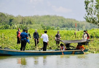 Presiden Jokowi menyempatkan diri menaiki perahu rakyat untuk menyeberangi sungai demi menyapa warga secara langsung yang ada di seberang sungai