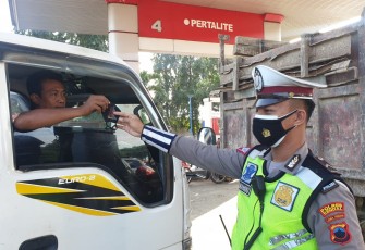 Anggota Satlantas Polres Kendal berikan masker kepada  pengendara mobil yang lewat di depan SPBU Jambe Arum