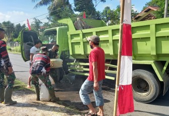 Personil satgas TMMD bantu sopir Dum Truk padamkan api yang keluar dari aki