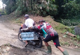 Personil satgas TMMD kodim Bitung saat bantu warga Dorong motor