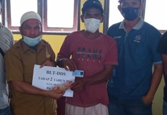 Pj Kepala Desa Kayu Menang, Salihin,A.Md saat menyerahkan BLT-DD kepada keluarga penerima manfaat