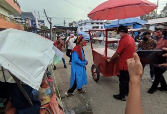 Walikota Bitung Maurits Mantiri MM yang di dampingi Dirut PD Bangun Bitung saat berikan satu unit gerobak kepada Oma Risma