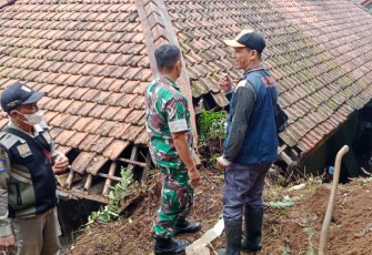 Petugas saat mengecek lokasi longsor terjang salah satu rumah warga.