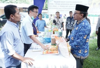 Kepala Dinas Koperasi Perdagangan dan Perindustrian Kabupaten Asahan Drs. Ilham, MM saat menyampaikan laporan kegiatan dihadapan Sekretaris Daerah Kabupaten Asahan, Asisten Perekonomian dan Pembangunan, Kepala Desa Sipaku Area serta tamu undangan lainnya di Halaman Balai Desa Sipaku Area Kecamatan Simpang Empat, Kamis (03/11/2022).
