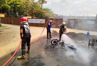 Petugas sedang memadamkan api yang membakar sebuah sepeda motor di sekitar kawasan Gedung Wanita, Jalan Wahid Hasim, Padangan, Jungke, Kecamatan. Karanganyar, Kabupaten Karanganyar, Kamis (25/8/2022) siang.