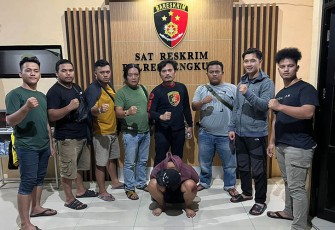 Tersangka (jongkok diborgol) saat diamankan