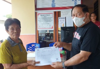 Kadis Kependudukan dan pencatatan sipil saat menyerahkan KK salah satu warga pada saat melaksanakan manuver Jebol Adminduk.