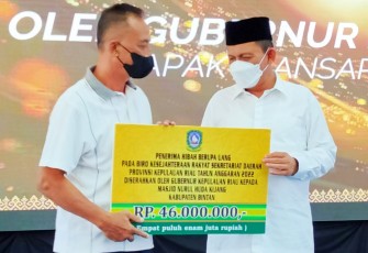 Penyerahan secara simbolis dana hibah dari Gubernur Ansar (kanan) ke salah satu penerima