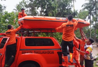 Tim BPBD setempat saat menurunkan perahu karet guna membatu korban terdampak banjir.