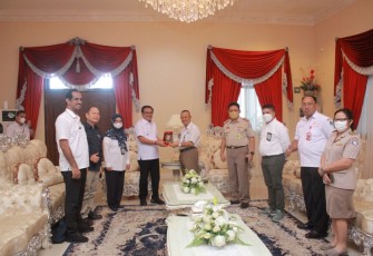 Wali Kota Bitung saat memberikan cindera mata kepada asisten deputi peningkatan daya saing Kemenko Marves