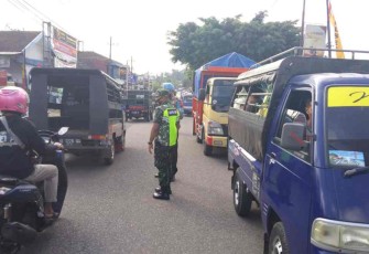Sertu Rohmat siaga membantu warga Seberangkan jalan. Kamis (05/05/2022)