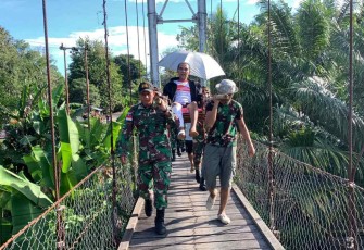 Tandu warga yang sakit melintasi jembatan gantung di perbatasan 