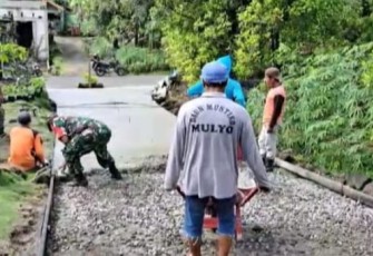 Serka Erwan saat meratakan cor jalan di desa binaan