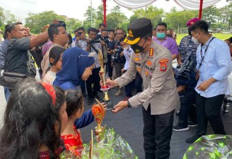Kapolresta Medan saat memberikan bunga dalam peringati hari anak nasional di Medan