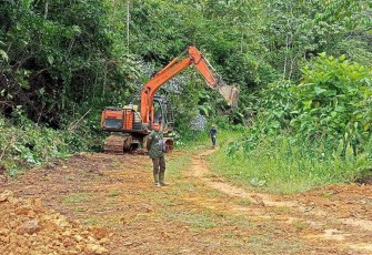Pembersihan badan jalan dusun Bahenap gunakan excavator 