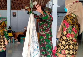 Babinsa saat bantu pelayanan posyandu wilayah binaan