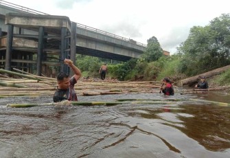 Prajurit satgas yonif 645/Gty terjun langsung bersihkan sampah di aliran sungai