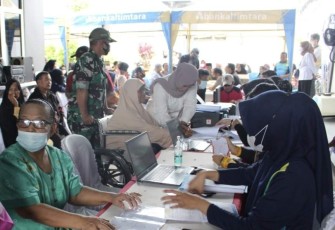 Serma Dahlan saat membantu warga dampingi pengambilan BLT