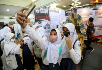 Antusias pelajar berswafo background replika Tandu Jenderal Sudirman dalam pameran kesejarahan di gedung Mulya Damai Kota Tegal, Jateng, Rabu (7/12)