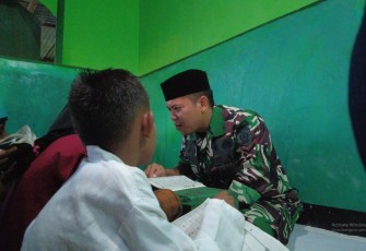 Prajurit Ajusta saat Ajarkan Mengaji pada Anak-anak di Daerah Penugasan   