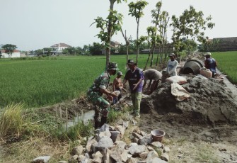 Babinsa Koramil Sawahan Bersama Warga saat Karya Bakti Bangun Talud