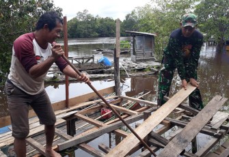 Personel TMMD saat Bongkar Warung Kelontong Warga Demi Kelancaran Pembangunan Akses Jembatan Titian 