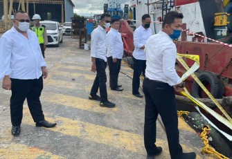 Petugas saat memasang garis polisi di area galangan kapal