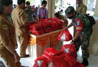 Babinsa Koramil Kurun saat Bantu Salurkan Bantuan Sembako Untuk Korban Banjir 
