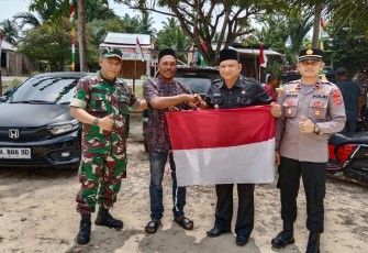 Kapolsek Peureulak Barat Bersama Muspika Bagikan Bendera Merah Putih ke Masyarakat