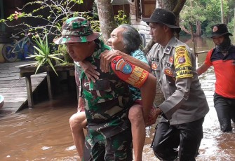 Anggota TNI dan Polri saat bantu lansia terdampak banjir untuk dapat pelayanan kesehatan.