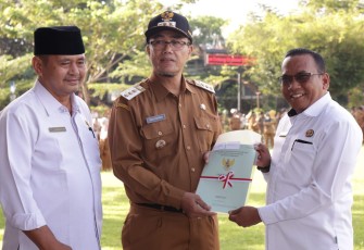 Pj.Wali Kota Payakumbuh, Rida Ananda menyerahkan sertifikat tanah secara simbolis kepada salah seorang penerima.