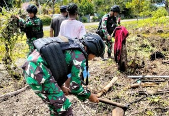  Satgas Yonif Raider 142/KJ saat Bantu Warga Bersihkan Kebun