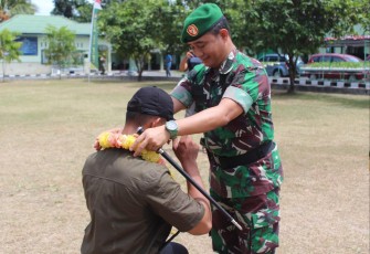 Dandim 1310/Bitung saat mengalungkan bunga kepada personil Komcad Darat T.a 2023 dilapangan Makodim Bitung