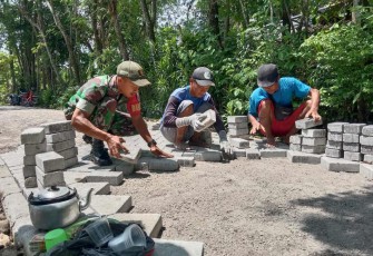 Pemasangan paving jalan desa binaan
